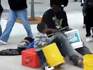 Un enfant très jeune joue de la musique dans la rue avec son père ! Enorme !