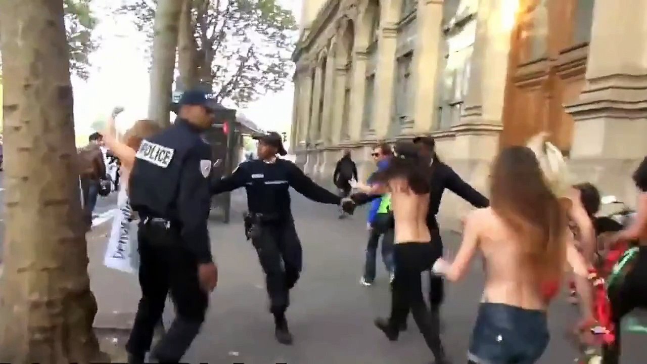 CRS mange un mur en tentant d'arrêter une femen