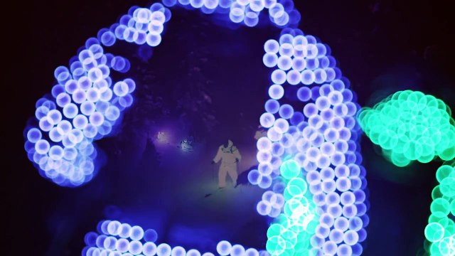 Skieurs en combinaisons lumineuses pendant la nuit