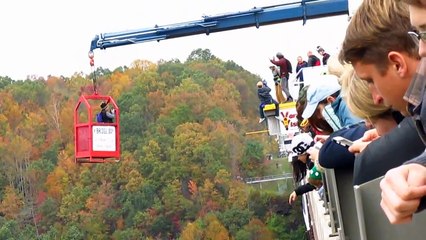 Un base jumper glisse d'un pont