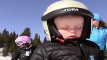 Un petit garçon qui tombe endormi en faisant du ski