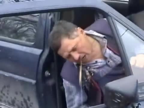 Un homme saoul tombe de sa voiture en vomissant