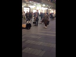 Elderly gentleman dances to street performer