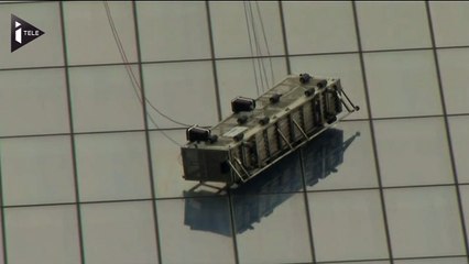 Deux laveurs de vitre suspendus dans le vide, à New York