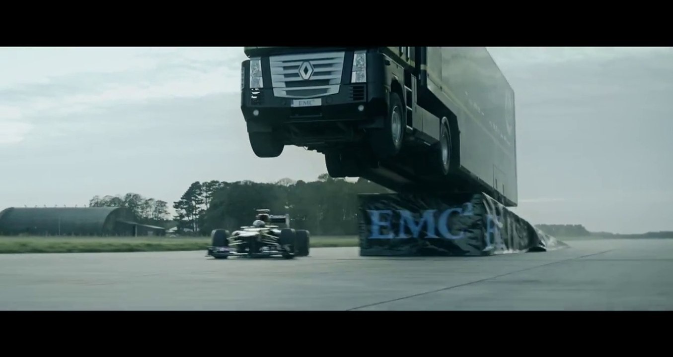 Un camion saute au dessus d'une F1 qui roule