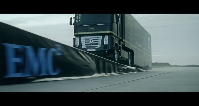 Un camion poids lourd saute au dessus d'une formule 1 pour une pub Lotus F1 Team et EMC