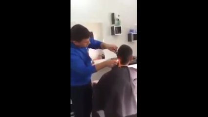 Un coiffeur utilise un briquet pour faire une coupe de cheveux