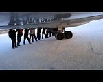 Pistte tekerleri buz tutan uçağı yolcular iterek çalıştırdı