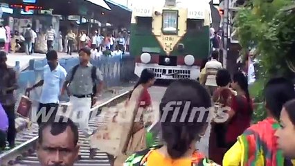 Passengers Crossing the railway track in front of the moving train By wildindiafilms