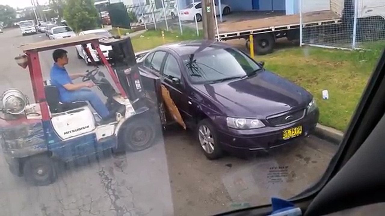 Un gars dégage une voiture gênante avec un chariot élévateur