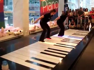 Deux jeunes femmes jouent un morceau très technique sur un piano géant !