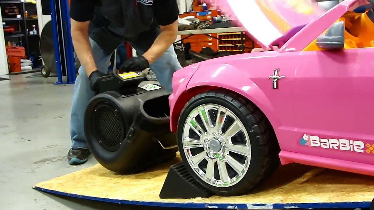Il teste la puissance du moteur d'une voiture Barbie à l'aide d'un dynamomètre