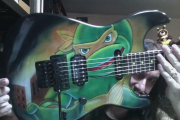 Charvel San Dimas Wild Card 7 Primer Scream with Teenage Mutant Ninja Turtles Custom Michaelangelo paint finish.