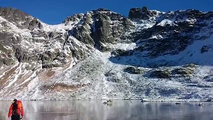 Buz tutan gölün üzerinde yürüyen adam