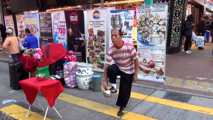 Street performer lands vases on his head using foot