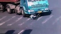 Un cycliste chanceux passe sous un camion