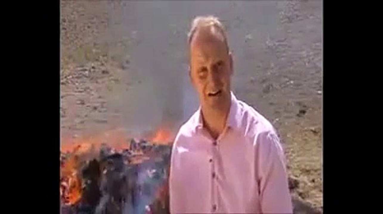 Journaliste défoncé devant un tas de drogue qui brûle