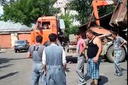Des hommes viennent en aide à un camion benne surchargé