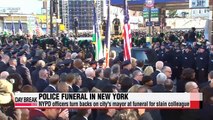 NYPD officers turn backs on city's mayor at funeral for slain colleague