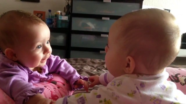 Bébés jumelles parlent et se tiennent la main pour la première fois