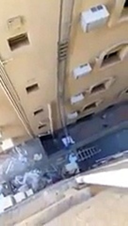 Un ouvrier répare une ventilation au sommet d'une échelle de 20 mètres