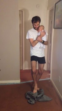 Funny dad putting pants while holding his baby : hilarious!