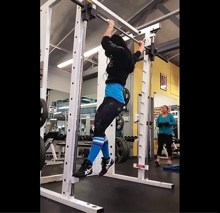 Une fille danse sur une barre de pull up