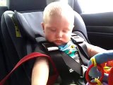 Un bébé en voiture résiste contre le sommeil