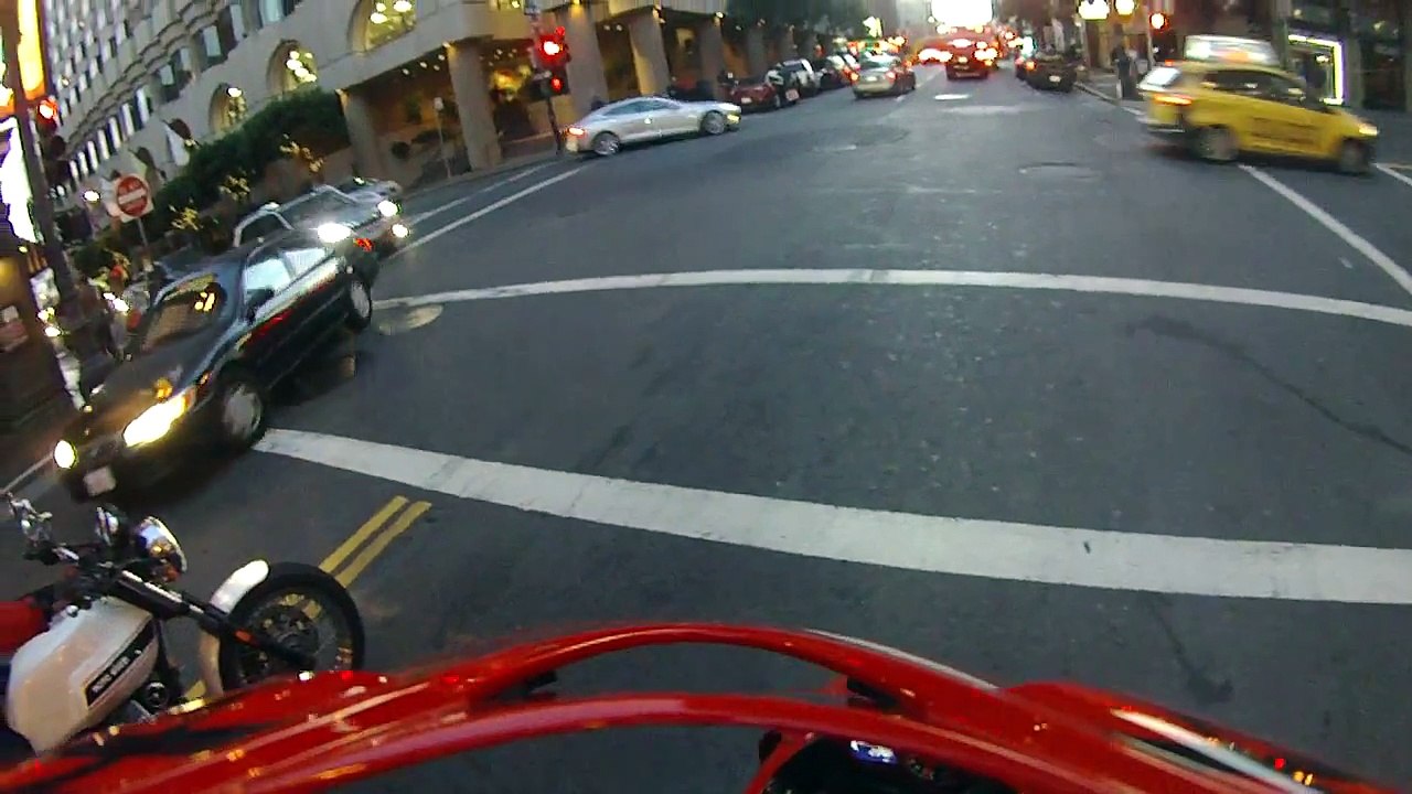 Une voiture percute un motard qui retombe sur ses pieds