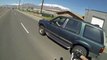 Un motard récupert un Mug posé sur le pare-choc d'un 4x4 qui roule!