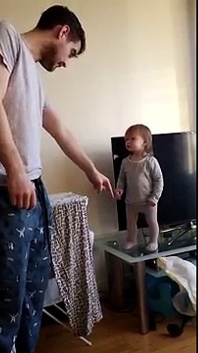 Bebê discute com o pai porque não quer sair de cima da mesa