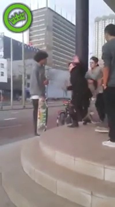 Un skateboarder Néerlandais pousse une vieille dame de quelques marches d'escaliers