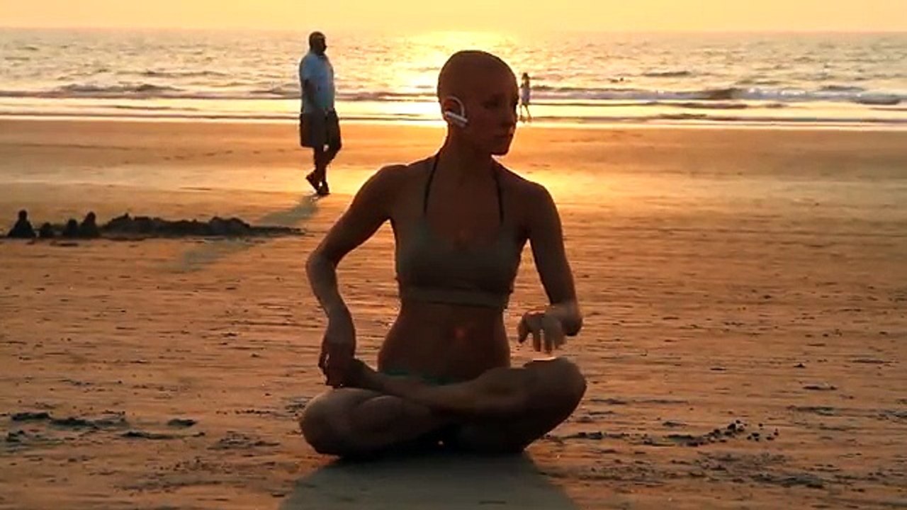 Eine Frau macht Yoga am Strand