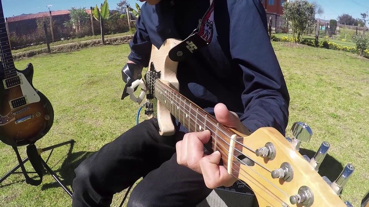 Un ado handicapé joue de la guitare avec une prothèse de bras imprimée en 3D.