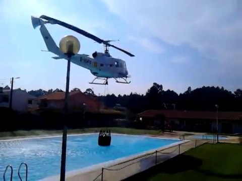 Helicopter refills its water bucket from a public swimming pool