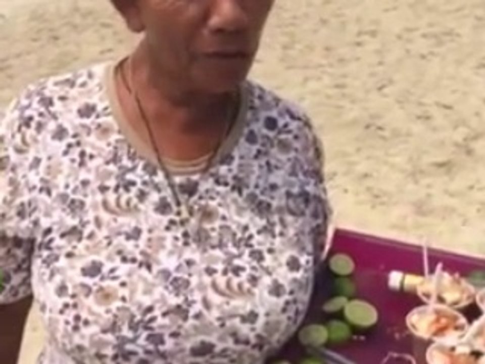 vieja vendiendo mariscos en la playa.