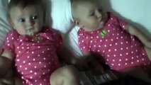 One baby blows raspberries to make the other baby laugh!