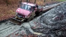 Un camion tire des énormes troncs d'arbres dans la boue