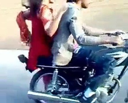 Pakistani Boy Performing One Wheeling with A Girl Sitting on Bike