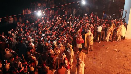 Hindu priest runs over giant fire as part of Holi festival