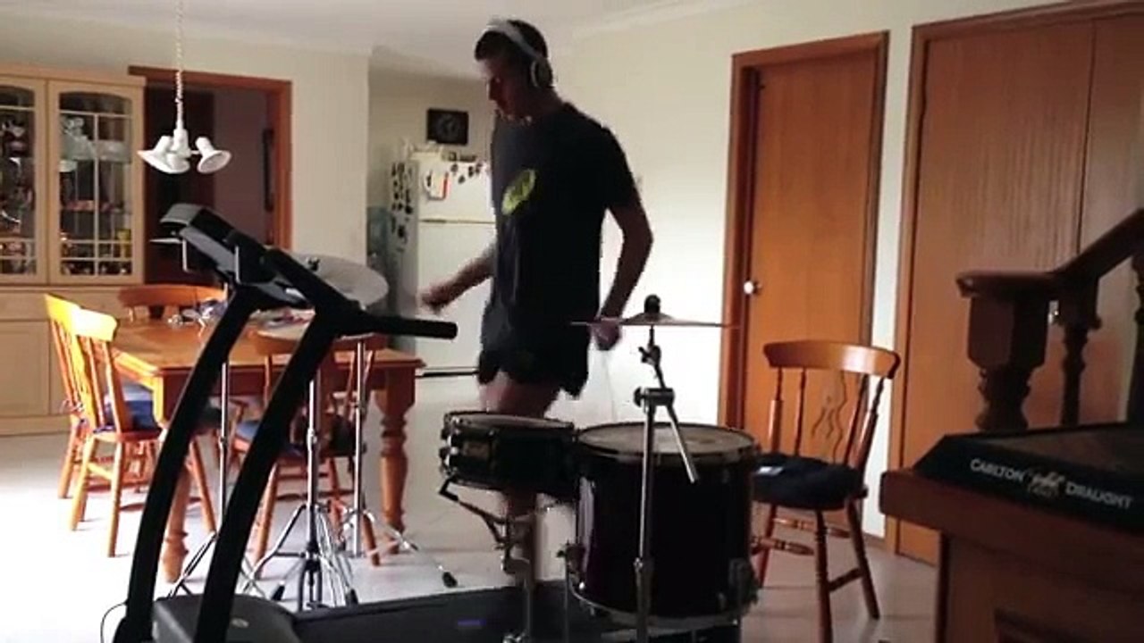 Il joue de la batterie en courant sur un tapis