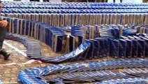 Watch thousands of copies of the Guinness World Records 2015 book topple like dominos!