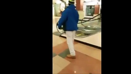 Il essaie de rester suspendu à un escalator