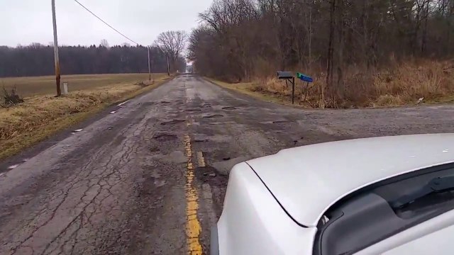 Un gars très énervé car il conduit sur la pire route du monde : nids de poule géants!