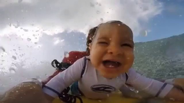 Un bébé fait du surf et il adore ça!