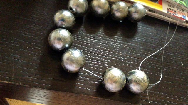 Pour faire briller un collier de perles noirs mettre du verni doré dessus