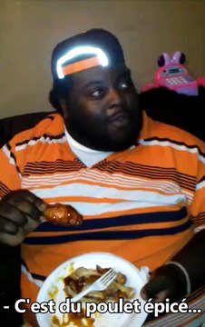 Un homme mange une aile de poulet épicée