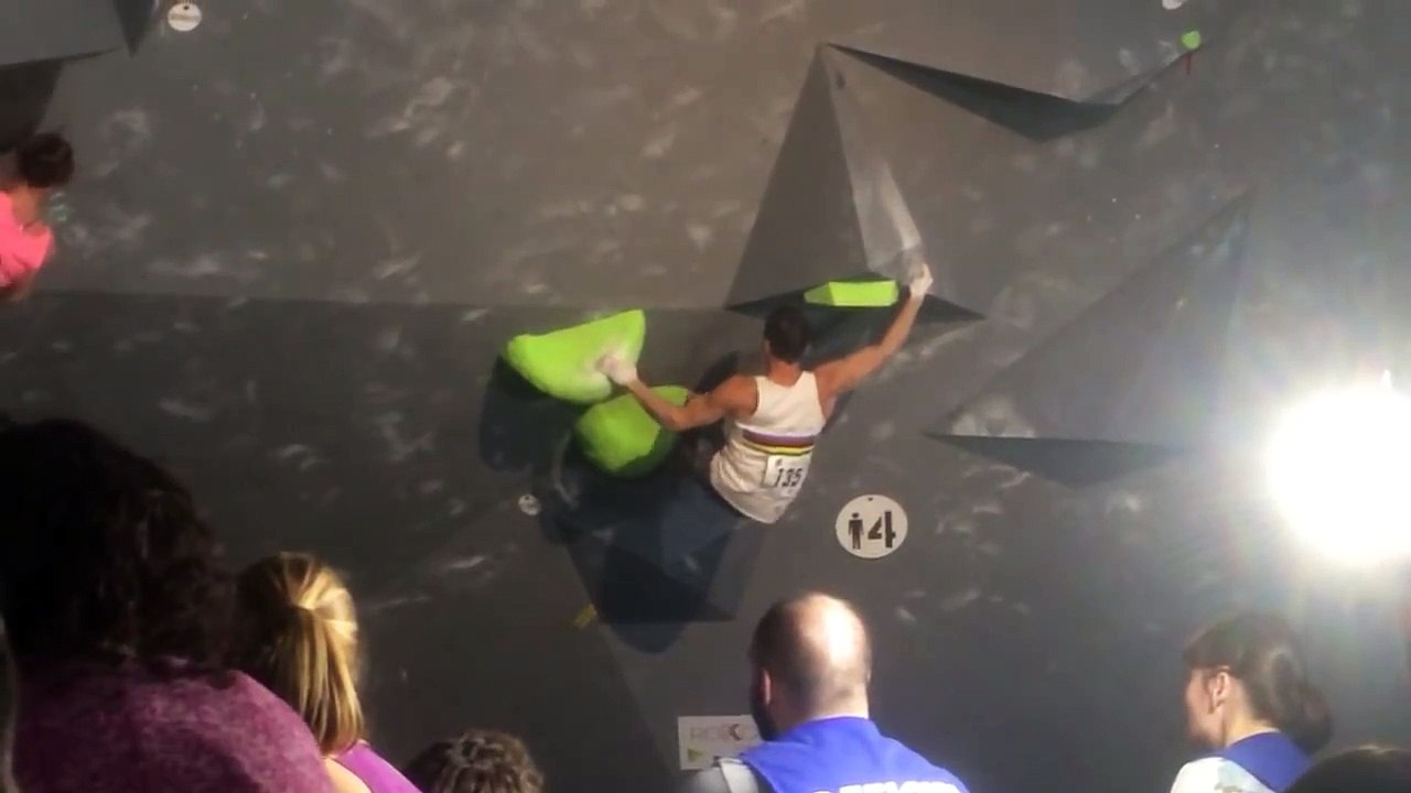 Un grimpeur réalise un mouvement fou pendant une compétition d'escalade