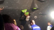 A climber makes a crazy motion for a climbing competition