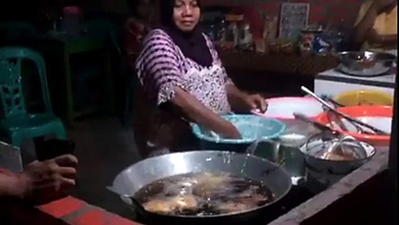 Mulher faz frituras com a mão no óleo